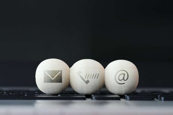 icon on wooden ball of website and internet contact us page concept on computer laptop keyboard